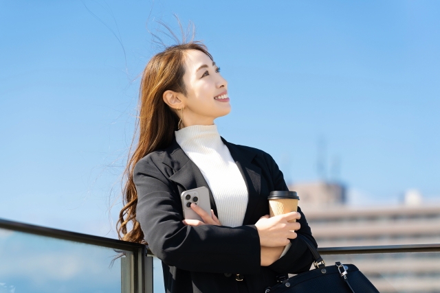 屋外でコーヒーを飲むビジネスパーソン