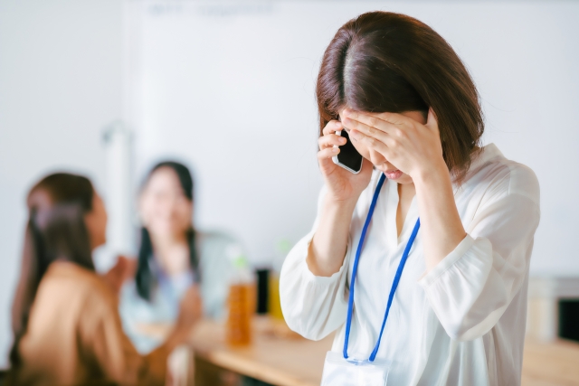 電話で話しながら額に手をあてる